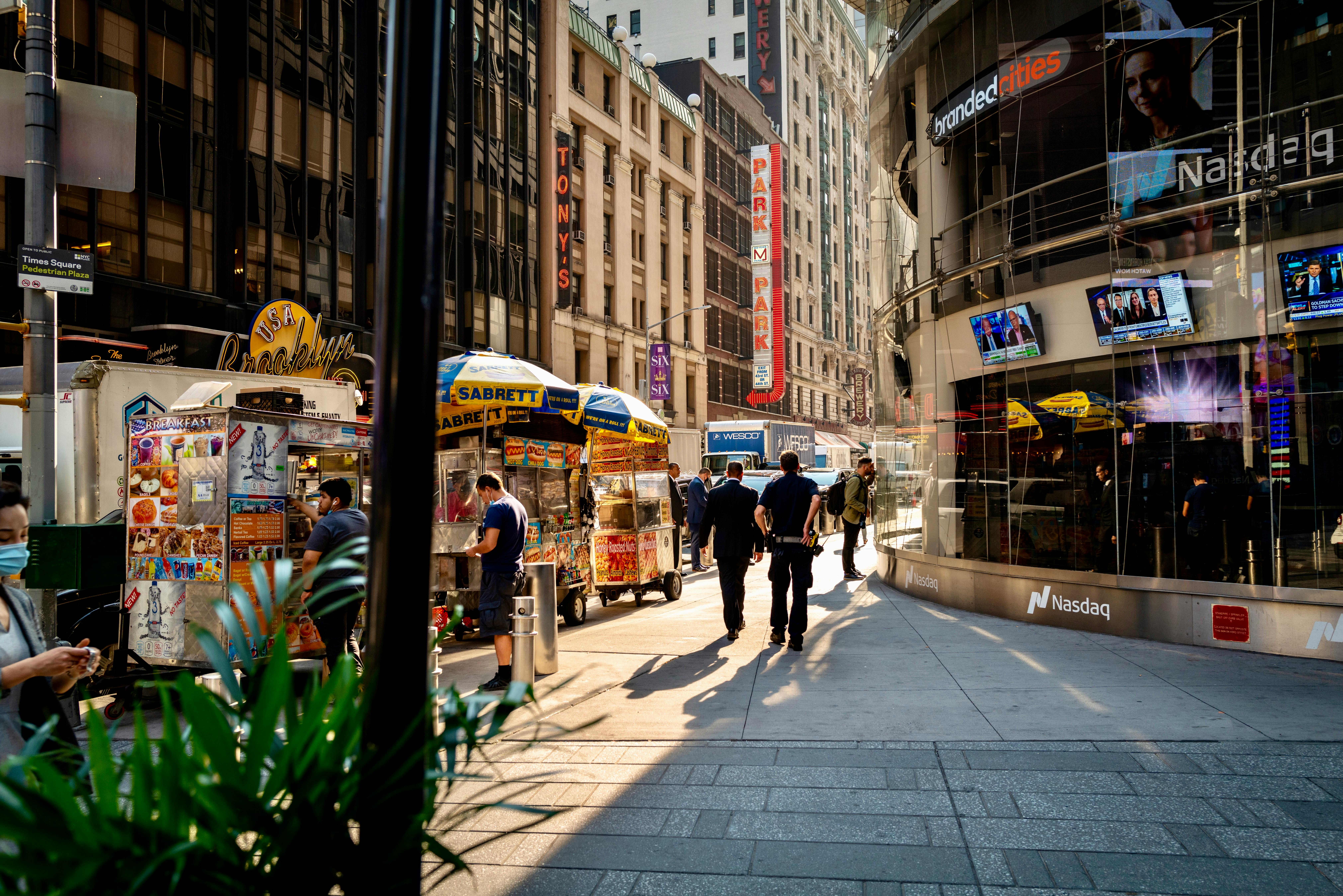 Busy city street with people walking near storefronts.